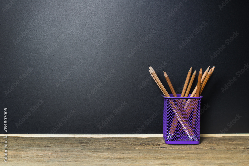 Pencil in basket on wood table with Blackboard (Chalk Board) as background  with copy space. Education and Back to school concept. Stock Photo