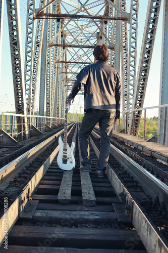 Man with an electric guitar in the industrial landscape outdoors © alexkich
