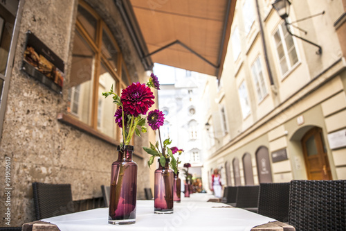 flowerpot. Nice view of an alley where you can see a table with purple flowers photo