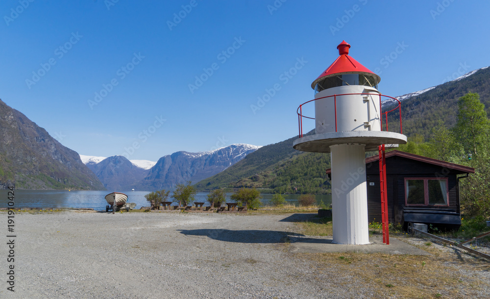 A lighthouse with small boat on the coast of Fjord in Flam, NOrway