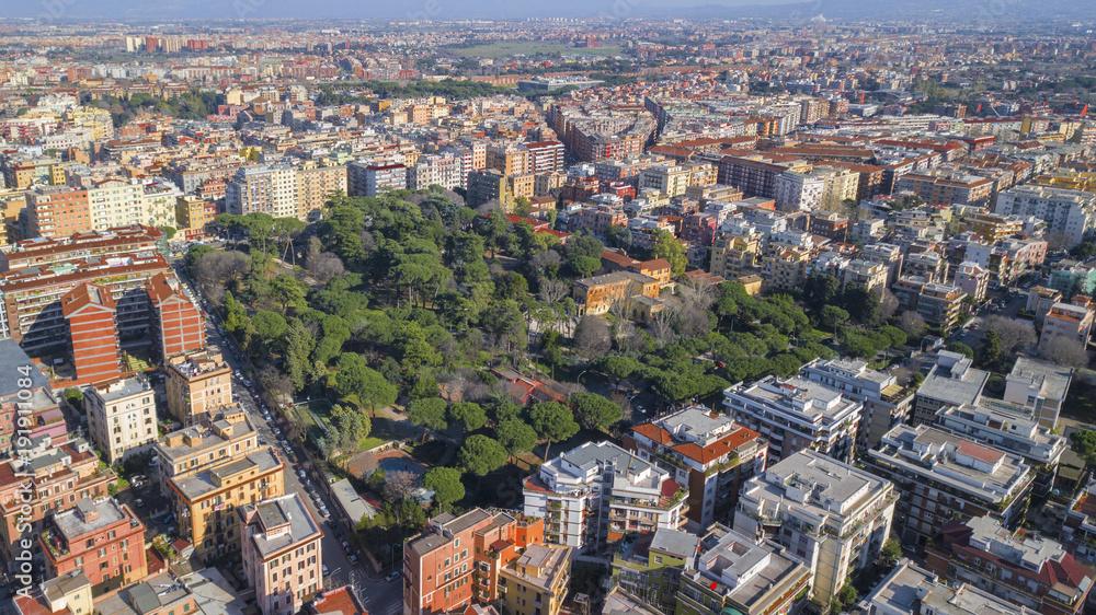 Aerial view of Villa Lazzaroni, a small park located between the tuscolana palaces in Rome, Italy. There is a building, a villa, within this green city area.