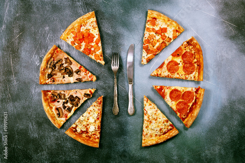 Slices of pizza with different fillings on a dark textured background