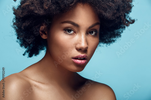 Young african woman isolated on blue wall studio fashion photoshoot confident photo