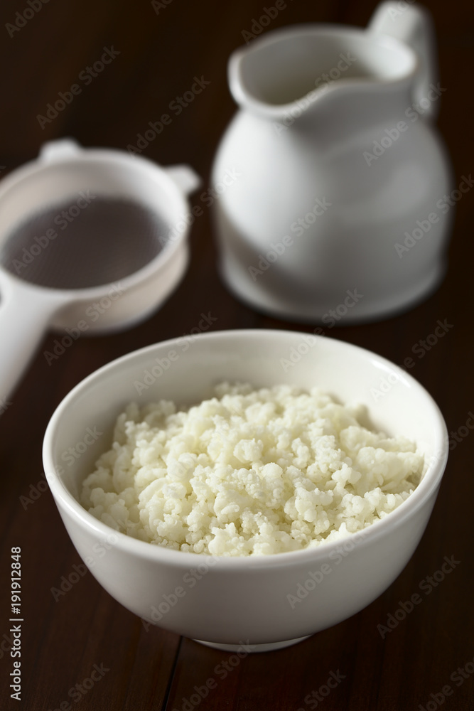 Kefirknollen zur Herstellung von frischem Kefirgetränk in Schüssel mit Milch und Sieb im Hintergrund, fotografiert mit natürlichem Licht (Selektiver Fokus, Fokus ein Drittel in die Kefirknollen) Kefirknollen zur Herstellung von frischem Kefirgetränk in Schüssel mit Milch und Sieb im Hintergrund, fotografiert mit natürlichem Licht (Selektiver Fokus, Fokus ein Drittel in die Kefirknollen)