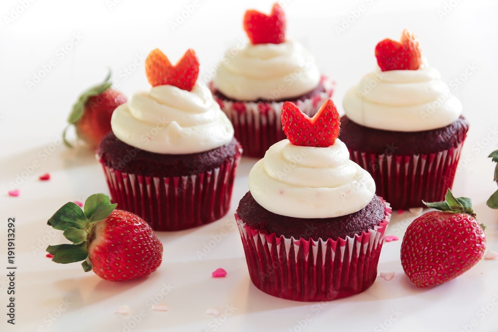Homemade Red velvet cupcakes with frosting and strawberry heart on white background