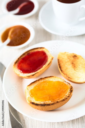Getoastete Brötchen mit Butter und Marmelade zum Frühstück oder Snack, fotografiert mit natürlichem Licht (Selektiver Fokus, Fokus in die Mitte des ersten Brötchens)