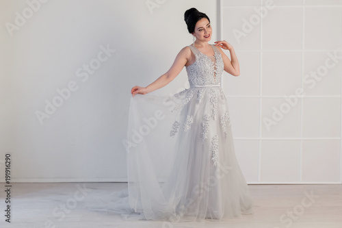 bride in wedding dress in white room