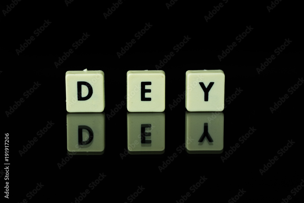 blocks with letters set on a glass table. Words arranged from letters on a glass substrate. The words dey blocks with letters set on a glass table. Words arranged from letters on a glass substrate. The words dey