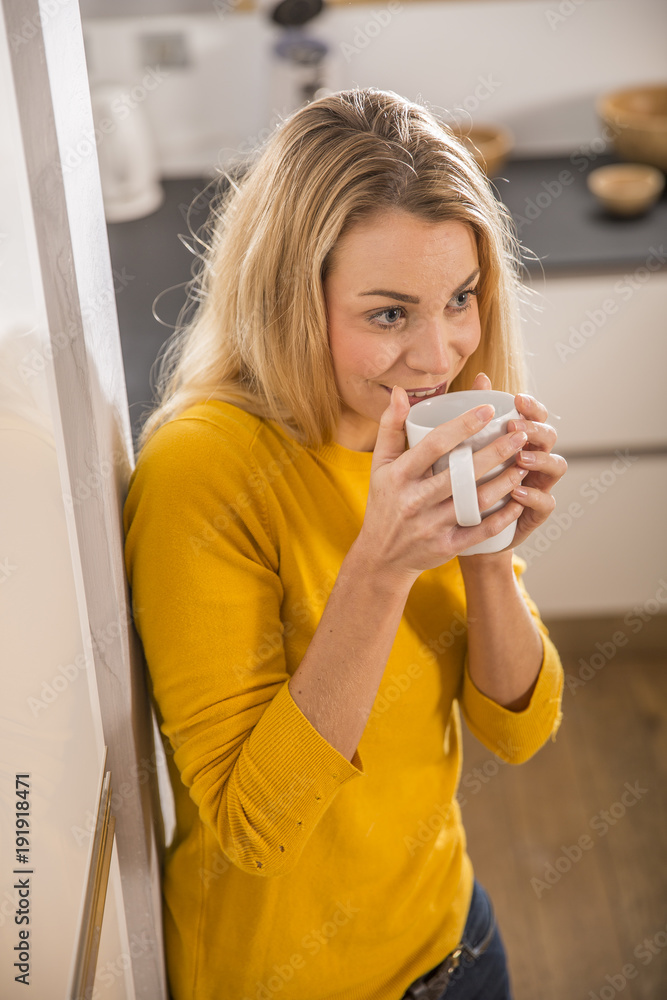 young woman in home kitchen, drinking coffee young woman in home kitchen, drinking coffee