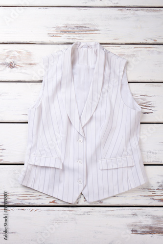 Female elegant waistcoat, top view. Women formal style clothes on wooden background.