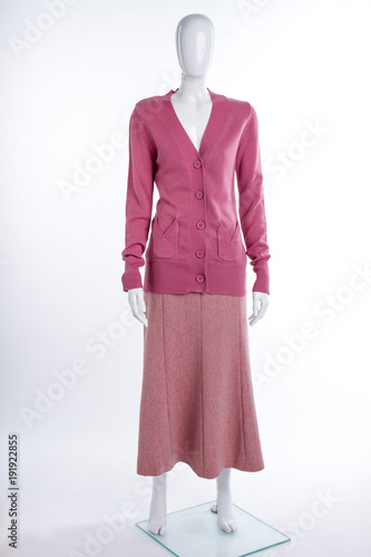 Pink cardigan and skirt for women. Female mannequin dressed in buttoned sweater and skirt, white background.