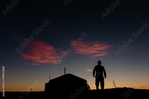 Silhouette of a Mongolian nomad and ger tent at sunrise photo
