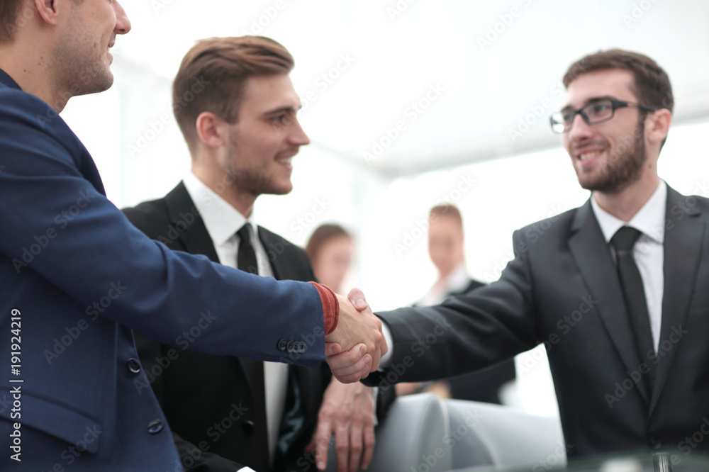 Partners concluding deal and shaking hands in the presence of team members Partners concluding deal and shaking hands in the presence of team members
