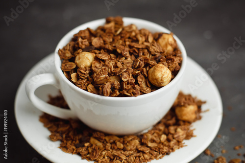 Granola in a white Cup on a black background. The concept of a healthy diet  weight loss  diet