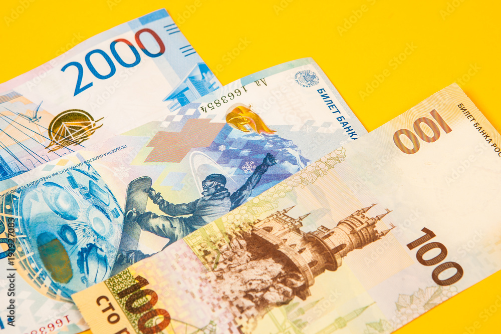 Obraz premium New design of money in Russia. A new bill of 100 rubles. Money of Russia on a background of yellow. New banknotes of a hundred rubles.