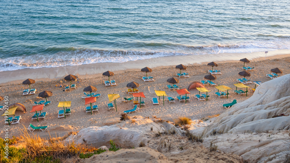 Sunbeds and umbrellas on the Falesia Beach