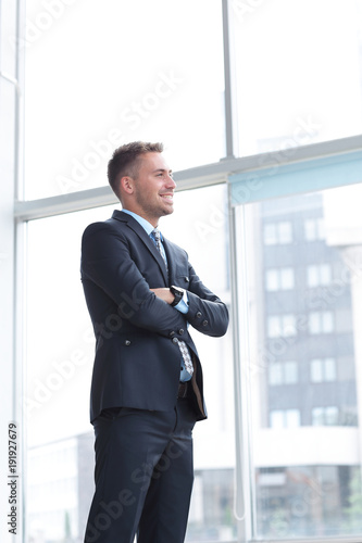 portrait of confident businessman looking out the window of the office.