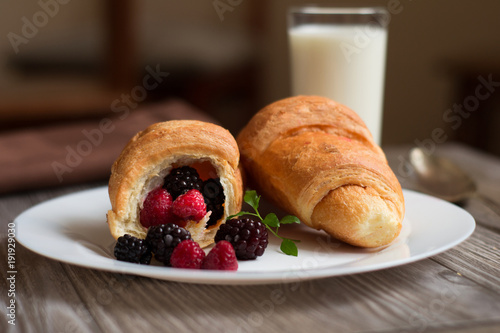 croissant on a large white plate on wooden table photo
