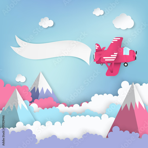 Paper art background with paper clouds, high mountains, pink airplane with banner. Flying origami paper art plane. Blue sky background with fluffy clouds. Pastel colors