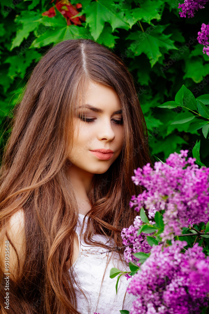 young beautiful girl in spring outdoors, near the flowering lilac trees, portrait of a young girl in white dress young beautiful girl in spring outdoors, near the flowering lilac trees, portrait of a young girl in white dress