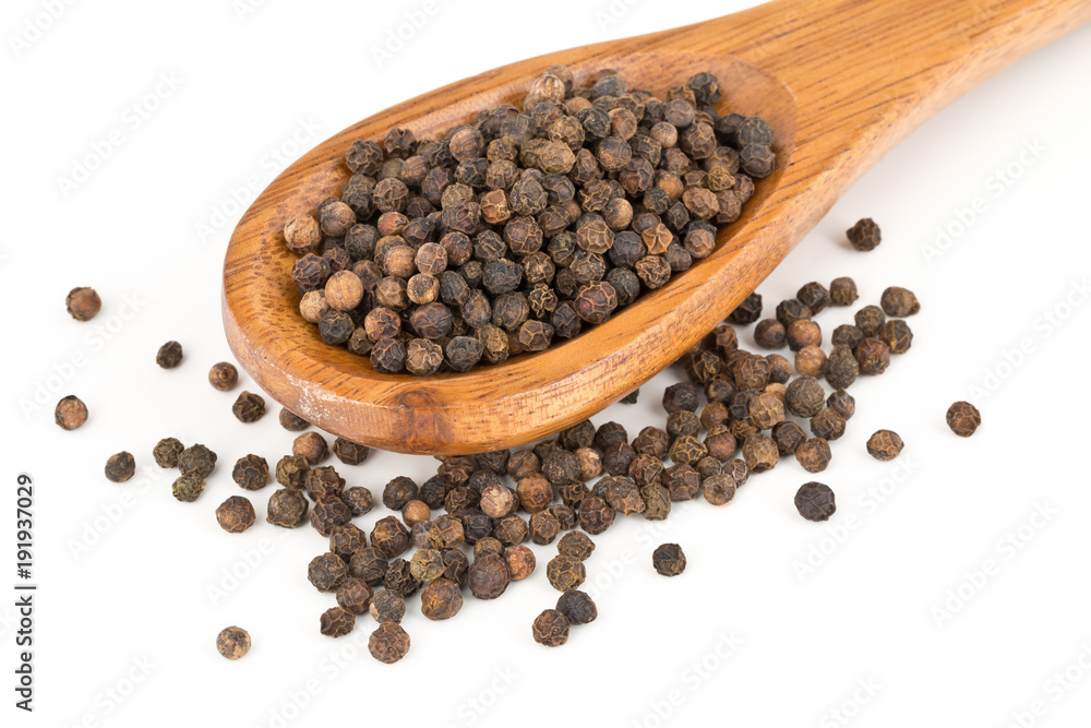 Heap of raw, natural, unprocessed black pepper peppercorns in spoon Heap of raw, natural, unprocessed black pepper peppercorns in spoon