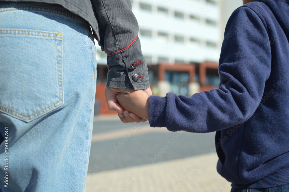 The child holds mum. Closeup on hands over sunny day outdoors background. Caring happiness The child holds mum. Closeup on hands over sunny day outdoors background. Caring happiness