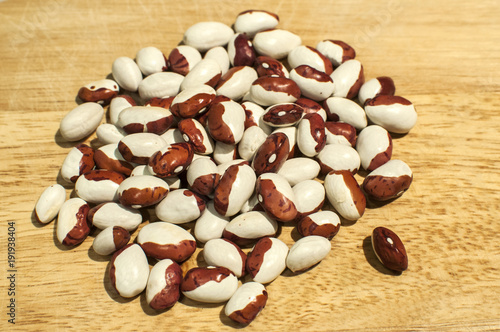 A pile of painted pony italian borlotti cranberry beans closeup on wooden board photo