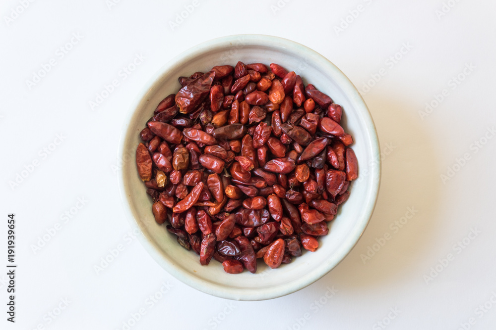 Bowl of Capsicum annuum Pequin pepper piquin bird pepper dried food ingredient, isolated on white, horizontal aspect Bowl of Capsicum annuum Pequin pepper piquin bird pepper dried food ingredient, isolated on white, horizontal aspect