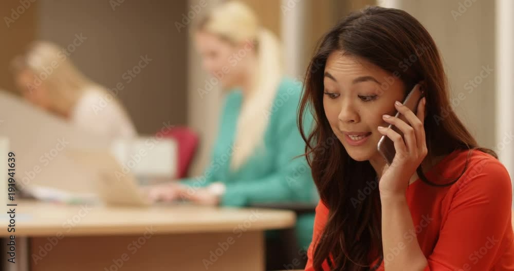 4K Concerned businesswoman making a phone call while looking over paperwork in the office