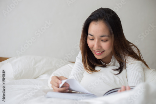 Happy Beauty Asian Woman reading book in the morning