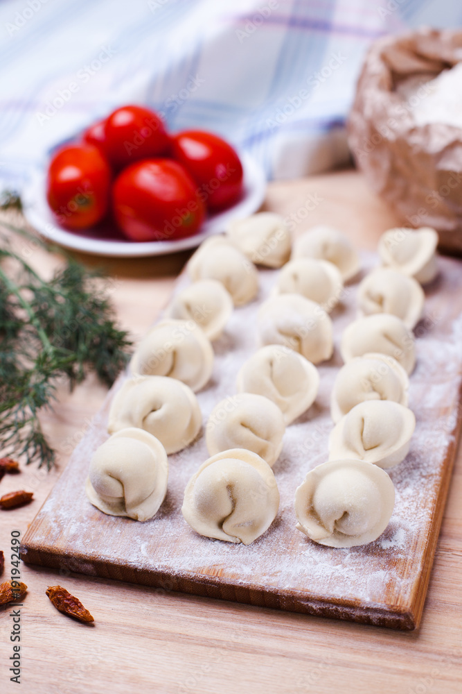 dumplings with meat on a wooden stand - cooking, raw unpeeled dumplings, national Russian, Ukrainian cuisine dumplings with meat on a wooden stand - cooking, raw unpeeled dumplings, national Russian, Ukrainian cuisine