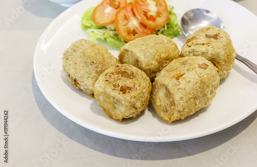 Thai food : Dlicious deep fried crab and shrimp roll served with sliced tomato and vegetable on white plate