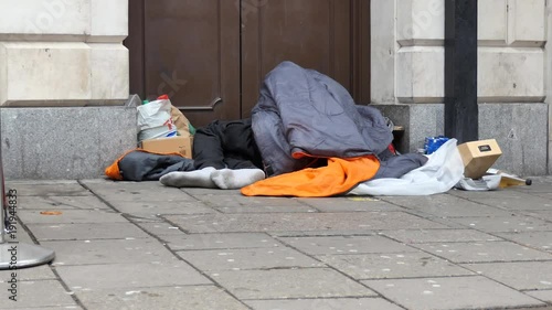 The homeless man sleeps on the sidewalk. London. photo