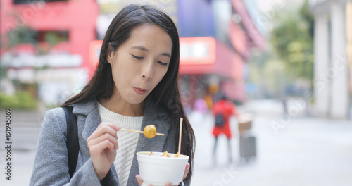Photography Woman eating fish ball, Hong Kong style snack
