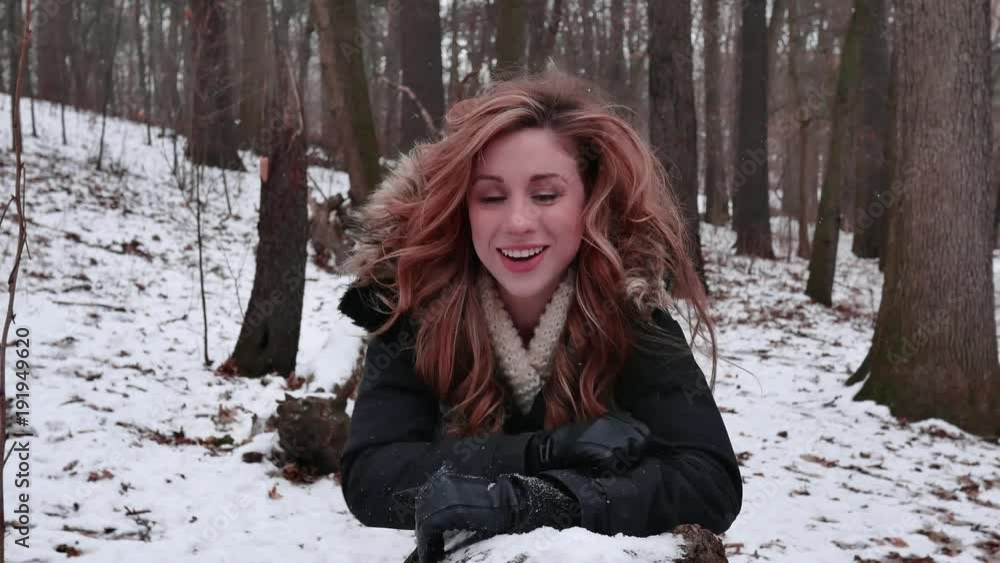 Woman almost falls of log lying in a winter wonderland Woman almost falls of log lying in a winter wonderland