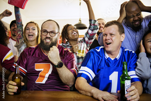 Frieds cheering sport at bar together