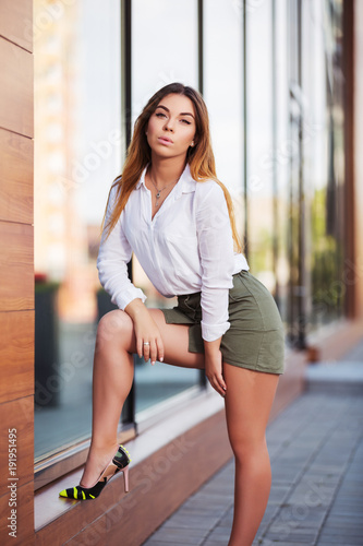 Canvas Print Young fashion woman in white shirt and short skirt at the mall window
