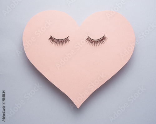 Wake up / Creative concept photo of heart with eye lashes on grey background.