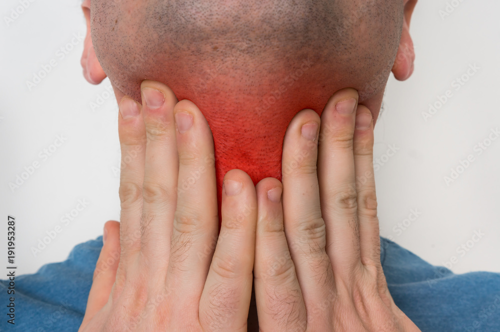 Man with throat sore is holding his aching throat