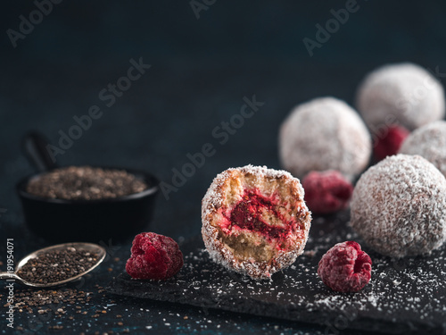 Photography Raw vegan lamington bliss balls with raspberries chia jam on dark background