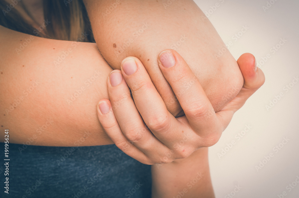 Woman with elbow pain is holding her aching arm Woman with elbow pain is holding her aching arm
