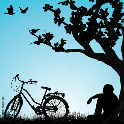 Relaxing bicyclist  under a tree
