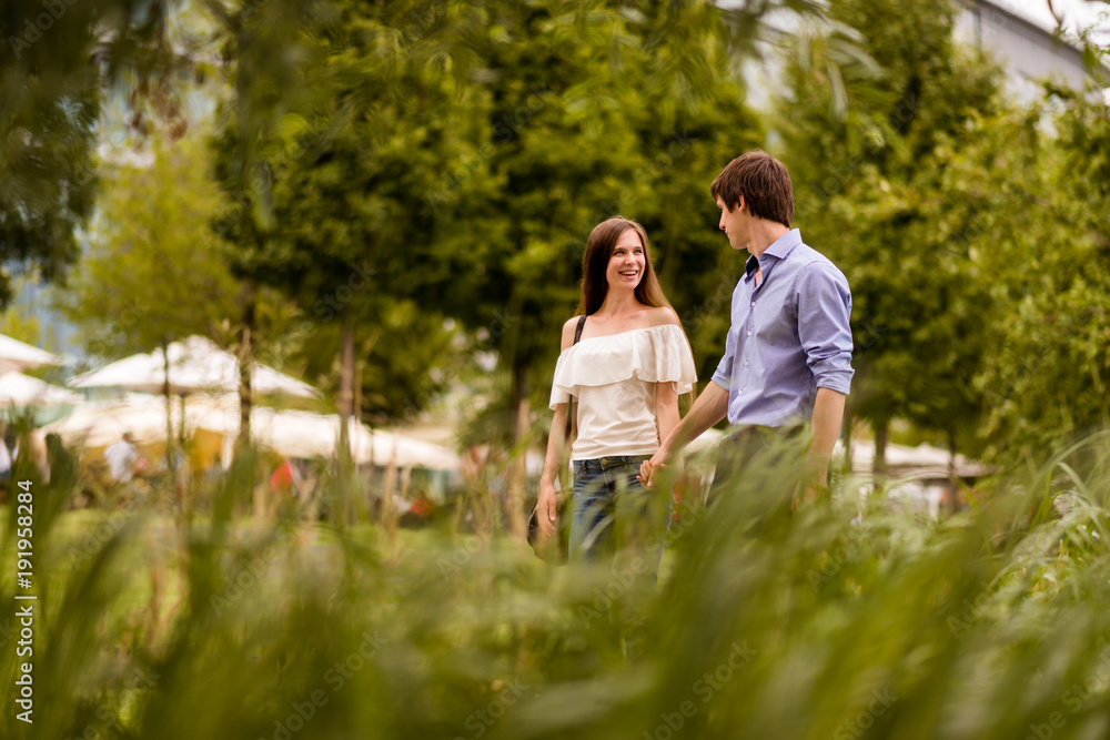 Cheerful young couple holding hands in park