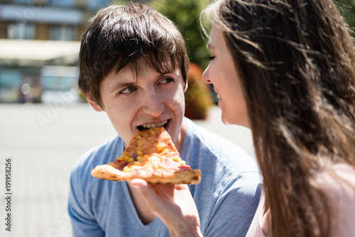 Cheerful couple sharing a pizza slice
