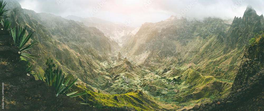 Xo-Xo valley with harsh peaks surrounded by mountains. Slopes are covered by agave plants. Small local village located in the valley. Santo Antao island, Cape Verde. Panoramic shot - obrazy, fototapety, plakaty 