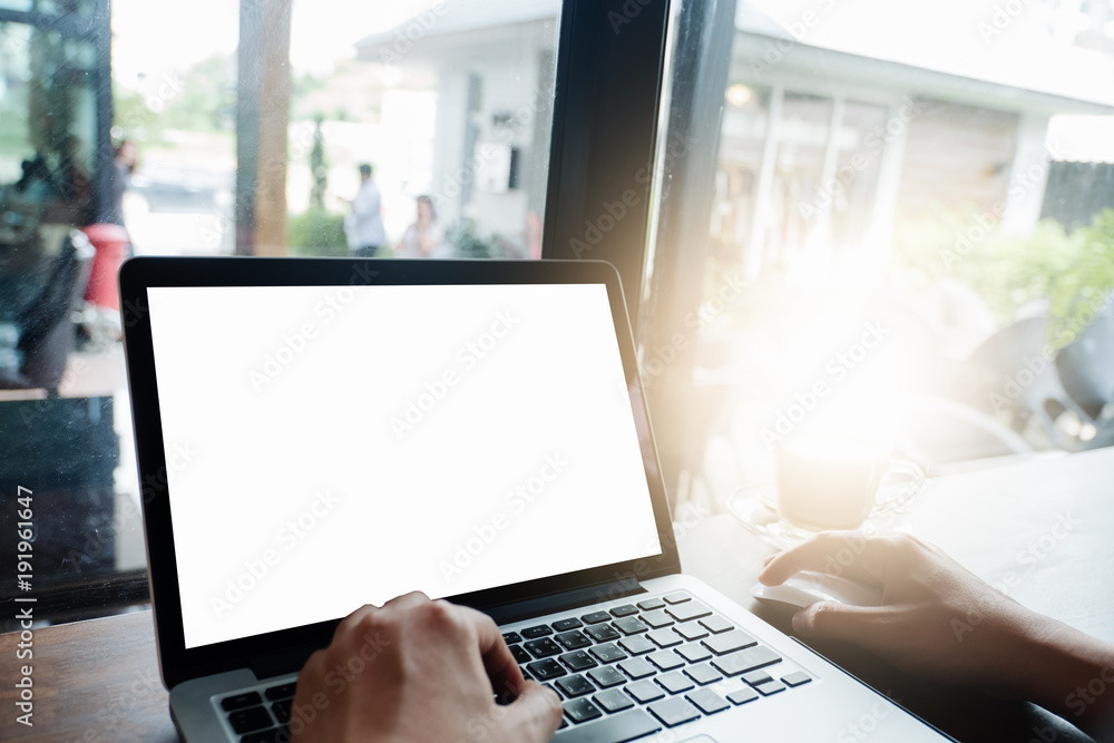 Mockup image of business man using and typing on laptop with blank white screen and coffee cup on glass table in modern loft cafe, Soft focus on vintage wooden table Mockup image of business man using and typing on laptop with blank white screen and coffee cup on glass table in modern loft cafe, Soft focus on vintage wooden table