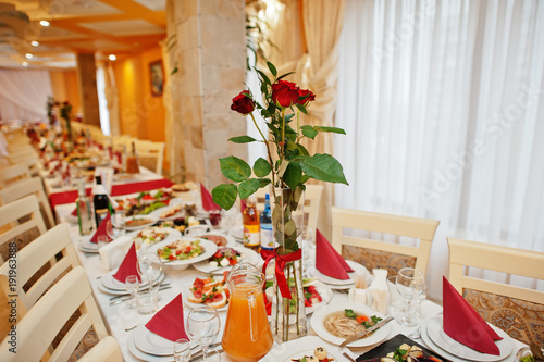 Wedding table decorated with red roses in the restaurant.