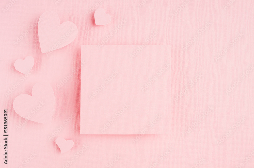 Valentines day background with blank page and paper hearts on gentle pink color background.