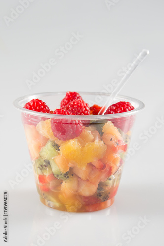 glass bowl with fresh fruits salad berries isolated on grey