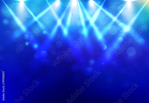 Spotlights lighting disco party stage with blured bokeh on blue dark background.